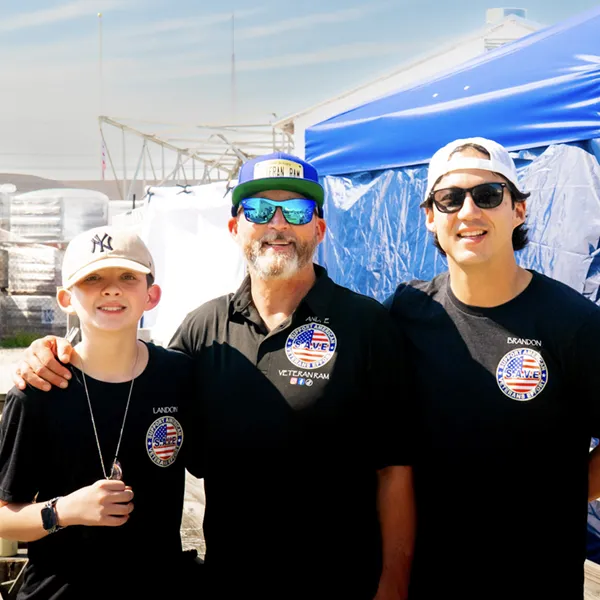 Andre and two volunteers wearing custom SAVE shirts