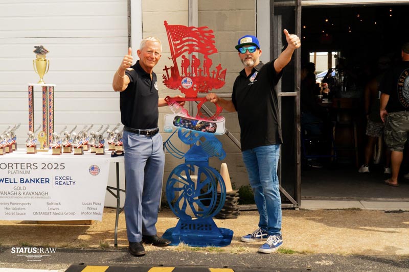 Andre with supporter in front of a custom metalwork sculpture