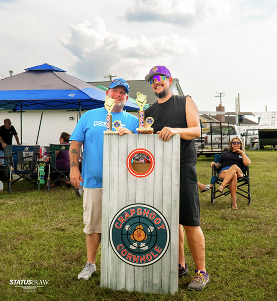 Crapshoot Cornhole tourney winners smiling with trophies