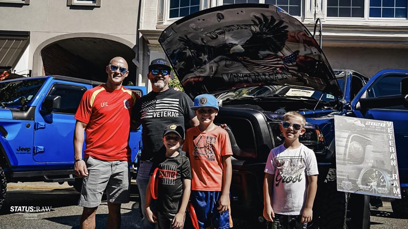 Andre posing with a family in front of the Veteran RAM truck