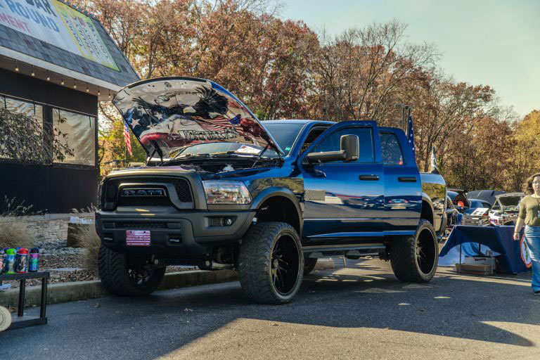 Veteran RAM truck with doors and hood open on display