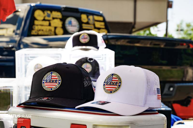 Two Save Veterans hats displayed on cooler in front of truck