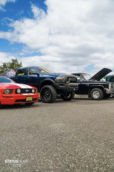 Lifted truck and cars lined up at outdoor car show