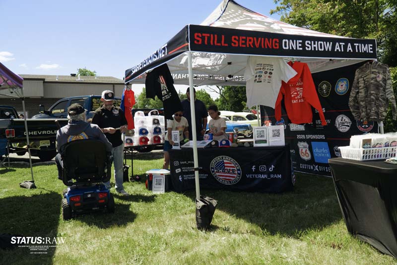Outdoor veterans booth with table, shirts, and visitors